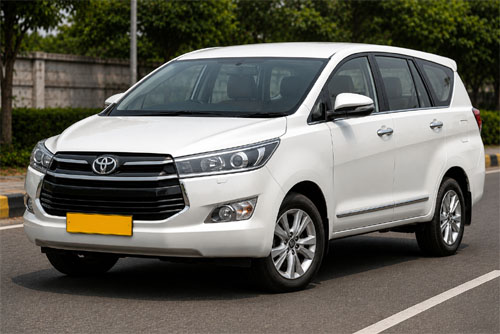 White Innova Crysta taxi with yellow commercial plate